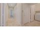 Hallway with tile floors and access to the laundry room and a carpeted bedroom at 11441 Drappo Ave, Las Vegas, NV 89138