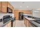 Modern kitchen with stainless appliances, black countertops, and center island with seating at 11441 Drappo Ave, Las Vegas, NV 89138