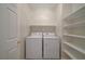 Laundry room with a washer, dryer, shelving and a white door at 11441 Drappo Ave, Las Vegas, NV 89138