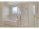 Bright bathroom featuring a soaking tub and glass door shower at 11441 Drappo Ave, Las Vegas, NV 89138
