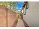 Narrow walkway on the side of a house, secured by a metal gate and high block wall at 11441 Drappo Ave, Las Vegas, NV 89138