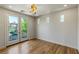 Bright bedroom featuring double doors to a balcony, hardwood floors, and stylish lighting at 11550 Lampeter Ct, Las Vegas, NV 89138