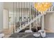 Dining area with elegant staircase, modern railing, and view of the kitchen at 11550 Lampeter Ct, Las Vegas, NV 89138