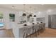Open kitchen features a large island with seating, modern pendant lighting, and stainless steel appliances at 11550 Lampeter Ct, Las Vegas, NV 89138