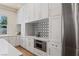 Elegant kitchen featuring white cabinets, gold hardware, stainless steel appliances, and modern backsplash design at 11550 Lampeter Ct, Las Vegas, NV 89138