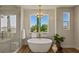 Contemporary main bathroom with a freestanding tub, glass-enclosed shower, and a scenic window view at 11550 Lampeter Ct, Las Vegas, NV 89138