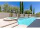 Inviting pool and spa with stone accents, set against a backdrop of mature trees and landscaping at 11550 Lampeter Ct, Las Vegas, NV 89138
