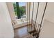 Modern staircase with sleek black railings leads to a cozy window seat overlooking the landscaped yard at 11550 Lampeter Ct, Las Vegas, NV 89138
