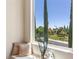 Inviting window seat with decorative pillows offers a picturesque view of the manicured lawn and lush greenery at 11550 Lampeter Ct, Las Vegas, NV 89138