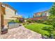 Well-maintained backyard featuring a stone patio, lush lawn, mature trees, and inviting outdoor seating area at 12286 Silvana St, Las Vegas, NV 89141