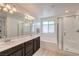 Bright and spacious bathroom with double sinks, a soaking tub, and a glass-enclosed shower at 12286 Silvana St, Las Vegas, NV 89141