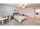 This bedroom features a neutral color palette, a ceiling fan, carpet and an ensuite bathroom at 12286 Silvana St, Las Vegas, NV 89141