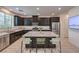 This spacious kitchen features dark cabinets, stainless steel appliances, a large island, and granite countertops at 12286 Silvana St, Las Vegas, NV 89141