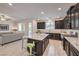 Kitchen with dark cabinets, tile floors, an island with seating and an open concept to the living area at 12286 Silvana St, Las Vegas, NV 89141