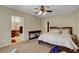Bright bedroom with plush carpet, ceiling fan, and a view into the bathroom at 1560 Plaza Centre Dr # 103, Las Vegas, NV 89135