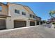 Modern townhome exterior with attached garages and paved driveway; desert landscaping and clear blue sky at 1560 Plaza Centre Dr # 103, Las Vegas, NV 89135