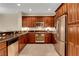 Well-equipped kitchen with stainless steel appliances, dark wood cabinets and tile floor at 1560 Plaza Centre Dr # 103, Las Vegas, NV 89135
