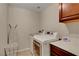 Bright laundry room includes washer, dryer, storage cabinet and built-in ironing board at 1560 Plaza Centre Dr # 103, Las Vegas, NV 89135