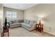 Neutral colored living room featuring a gray sectional couch and a window at 1560 Plaza Centre Dr # 103, Las Vegas, NV 89135