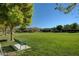 Lush community park with grassy field, mature trees, and park bench under clear skies at 1560 Plaza Centre Dr # 103, Las Vegas, NV 89135