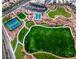 Aerial view of a community park, featuring a playground, sports courts, and expansive green spaces at 1560 Plaza Centre Dr # 103, Las Vegas, NV 89135