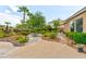 Lush backyard features a stone patio, garden area, mature trees, and manicured shrubs creating a private outdoor space at 1704 River Birch St, Las Vegas, NV 89117