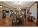 Refined dining room featuring a chandelier, hardwood floors, and a decorative hutch with plush upholstered chairs at 1704 River Birch St, Las Vegas, NV 89117
