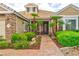 Inviting home exterior showcasing a brick pathway, manicured bushes, and decorative palm trees near the front door at 1704 River Birch St, Las Vegas, NV 89117