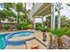 Outdoor spa with lounge seating under a pergola, surrounded by lush landscaping for ultimate relaxation and privacy at 1704 River Birch St, Las Vegas, NV 89117