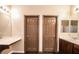 Dual vanity bathroom with a built in makeup counter, two matching doors, and wood look floors at 1808 Peyton Stewart Ct, North Las Vegas, NV 89086