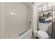 Bright bathroom featuring a shower-tub combo with white tile and functional shelving at 1916 Canosa Ave, Las Vegas, NV 89104