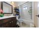 A bright bathroom with a dark wood vanity, a toilet, and a shower tub combo at 1916 Canosa Ave, Las Vegas, NV 89104