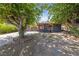 A single-story home with black exterior paint, contrasting orange trim and mature trees in the front yard at 1916 Canosa Ave, Las Vegas, NV 89104