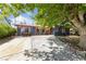 Charming home with black paint, vibrant orange trim, a spacious driveway, and a mature tree offering plenty of shade at 1916 Canosa Ave, Las Vegas, NV 89104