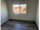 A bright bedroom featuring gray tone laminate flooring, a window and baseboard trim at 2036 Canosa Ave, Las Vegas, NV 89104