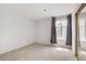 Well-lit bedroom with neutral carpet and large window with curtains at 207 E Van Wagenen St, Henderson, NV 89015