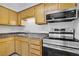 Galley kitchen featuring oak cabinets, updated countertops, and stainless steel appliances at 207 E Van Wagenen St, Henderson, NV 89015