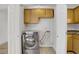 Convenient laundry closet with stainless steel washer and wooden cabinets at 207 E Van Wagenen St, Henderson, NV 89015