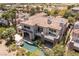 Aerial view shows a backyard pool and patio with open doors to the house and mature landscaping at 2436 Grassy Spring Pl, Las Vegas, NV 89135