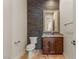 A powder room featuring a dark accent wall and a wood vanity with granite counters at 2436 Grassy Spring Pl, Las Vegas, NV 89135