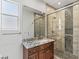 Bathroom featuring walk-in shower, decorative tiles, and vanity with a beautiful granite countertop at 2436 Grassy Spring Pl, Las Vegas, NV 89135