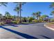 Community entrance with lush landscaping and mature palm trees on a clear sunny day at 2436 Grassy Spring Pl, Las Vegas, NV 89135