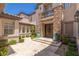 Grand entrance with stone facade, double doors, manicured bushes, and potted plants at 2436 Grassy Spring Pl, Las Vegas, NV 89135