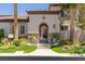 Inviting front entrance featuring a decorative wrought iron gate, lush plantings, and stone accents at 2436 Grassy Spring Pl, Las Vegas, NV 89135