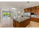 Gourmet kitchen boasts custom wood cabinets, granite counters, and stainless steel appliances with island at 2436 Grassy Spring Pl, Las Vegas, NV 89135