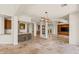 Spacious living room featuring stone floors, wet bar with granite counters and custom wood cabinetry at 2436 Grassy Spring Pl, Las Vegas, NV 89135