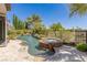 Backyard pool and jacuzzi feature a small waterfall and mature landscaping offering a luxurious and private oasis at 2436 Grassy Spring Pl, Las Vegas, NV 89135