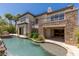 Elegant home with a stunning pool, waterfall, and lush landscaping at 2436 Grassy Spring Pl, Las Vegas, NV 89135
