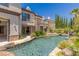 Backyard pool and patio with a stone waterfall feature, and ample greenery create a serene outdoor retreat at 2436 Grassy Spring Pl, Las Vegas, NV 89135