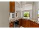 Wet bar features custom cabinetry, granite counters and stainless steel undercounter beverage refrigerator at 2436 Grassy Spring Pl, Las Vegas, NV 89135